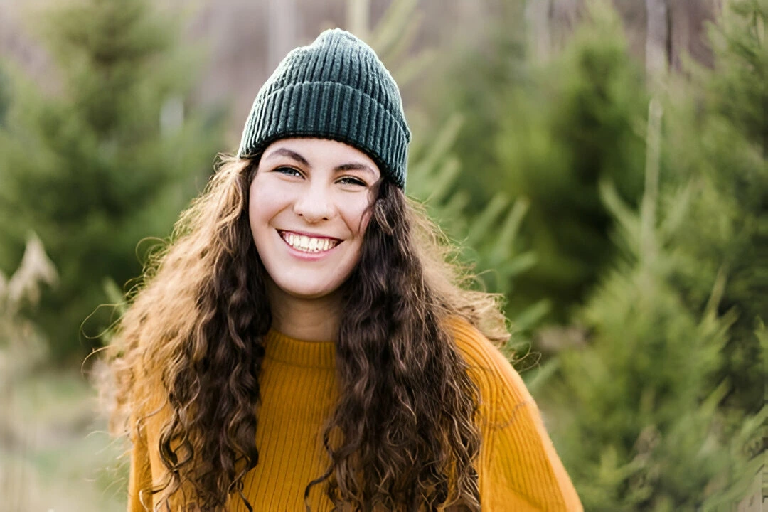 girl with long curly hair and a beanie